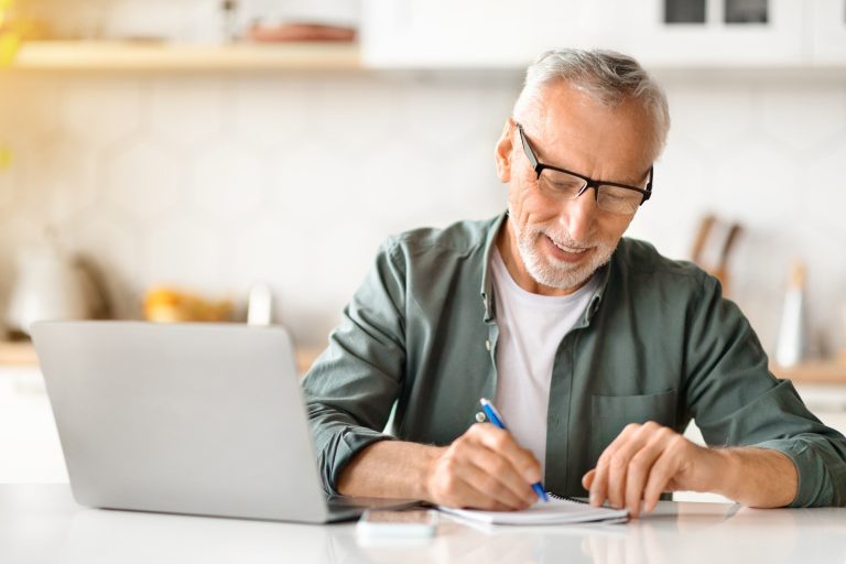 online-learning-for-older-adults-senior-man-using-laptop-and-taking-notes